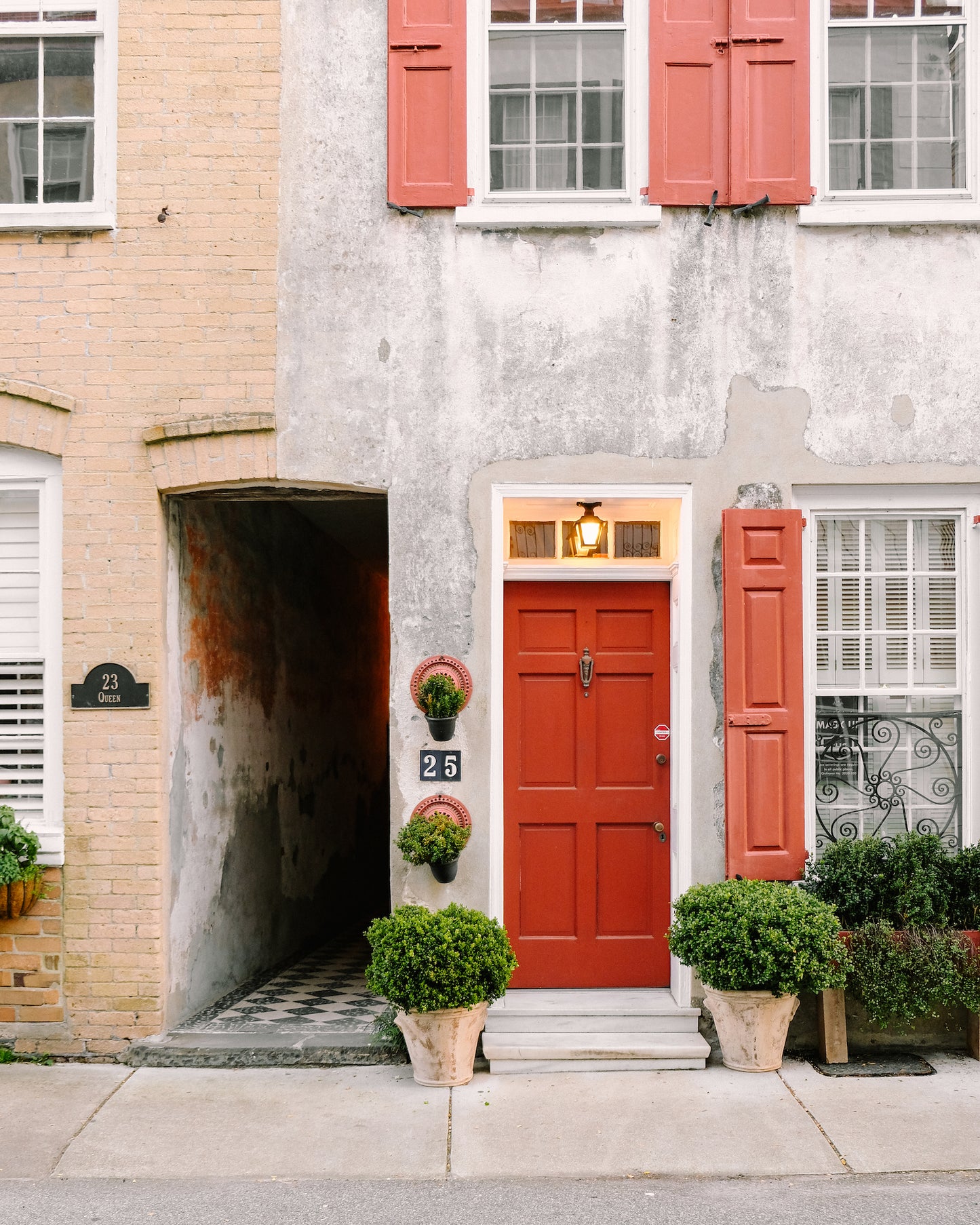 Historic Charleston facade with a red door and shutters at 25 Queen Street