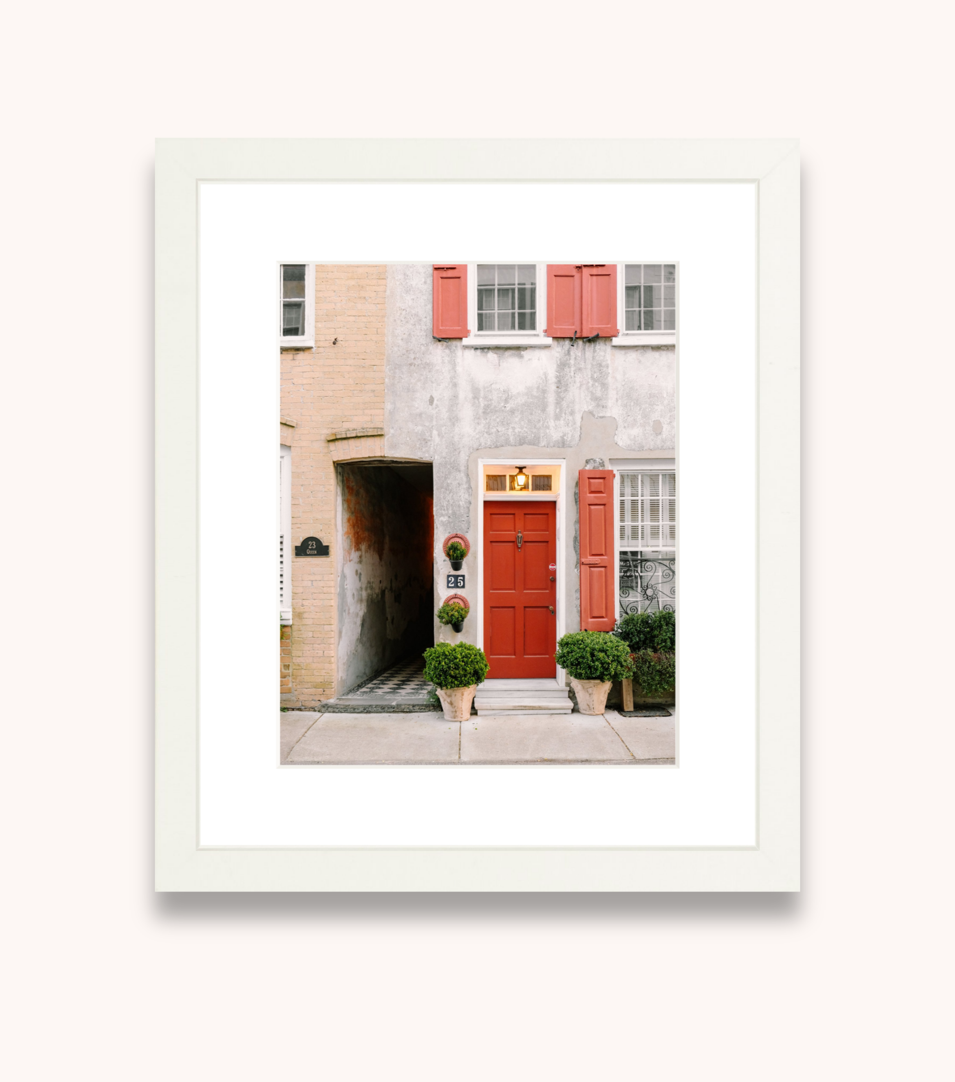 Framed Charleston wall art showcasing a red door and classic Southern architecture