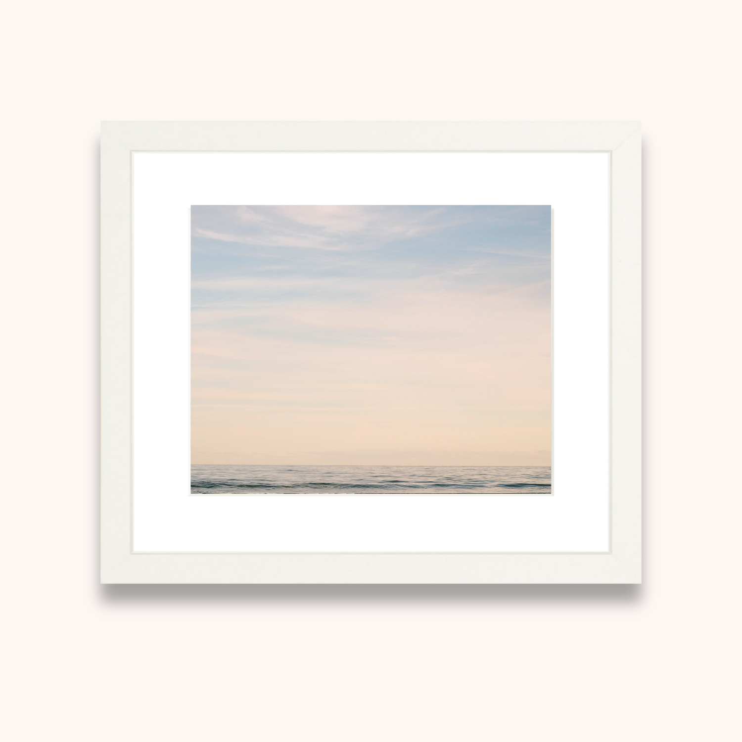 Framed artwork of a pastel sky over water on a white background