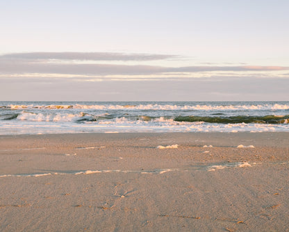 Golden sunset light reflecting on gentle waves at Folly Beach near Charleston