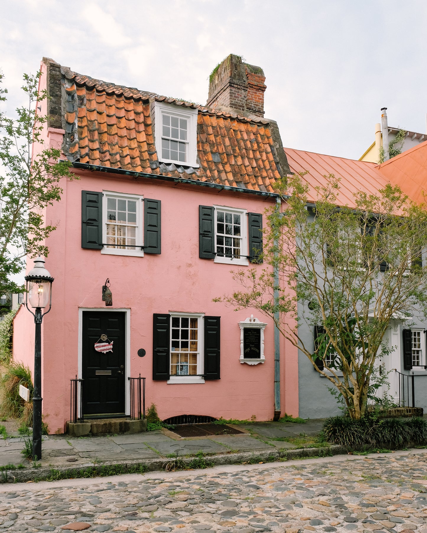 Pink historic home with black shutters on Chalmers Street in Charleston