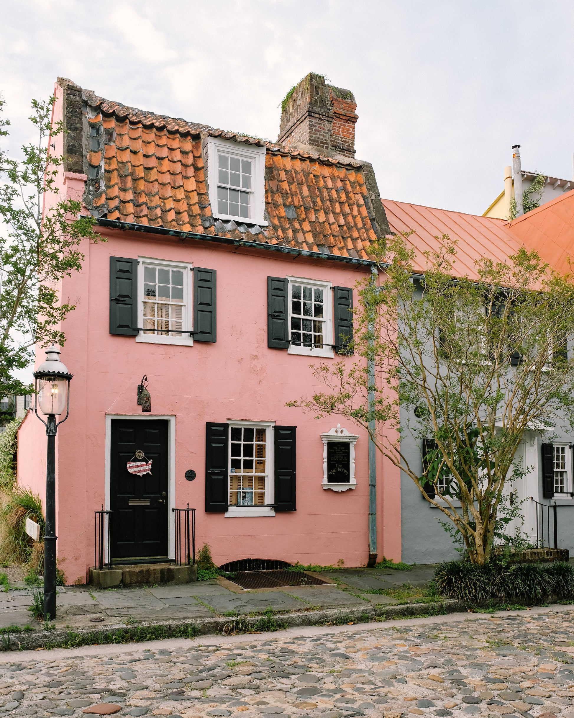 Pink historic home with black shutters on Chalmers Street in Charleston
