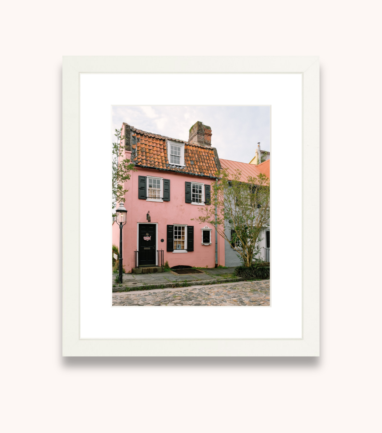 Framed Charleston wall art featuring a pink historic home and cobblestone street