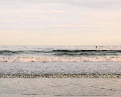 Paddleboarder on calm ocean water at sunrise in Charleston