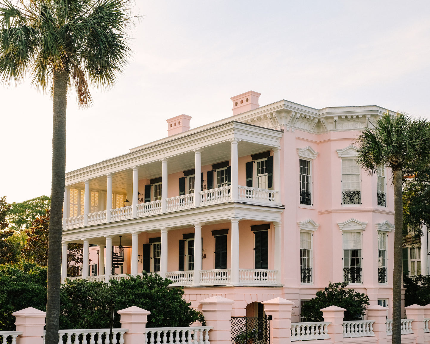 Pink historic home on the Battery in Charleston with palm trees and classic architecture