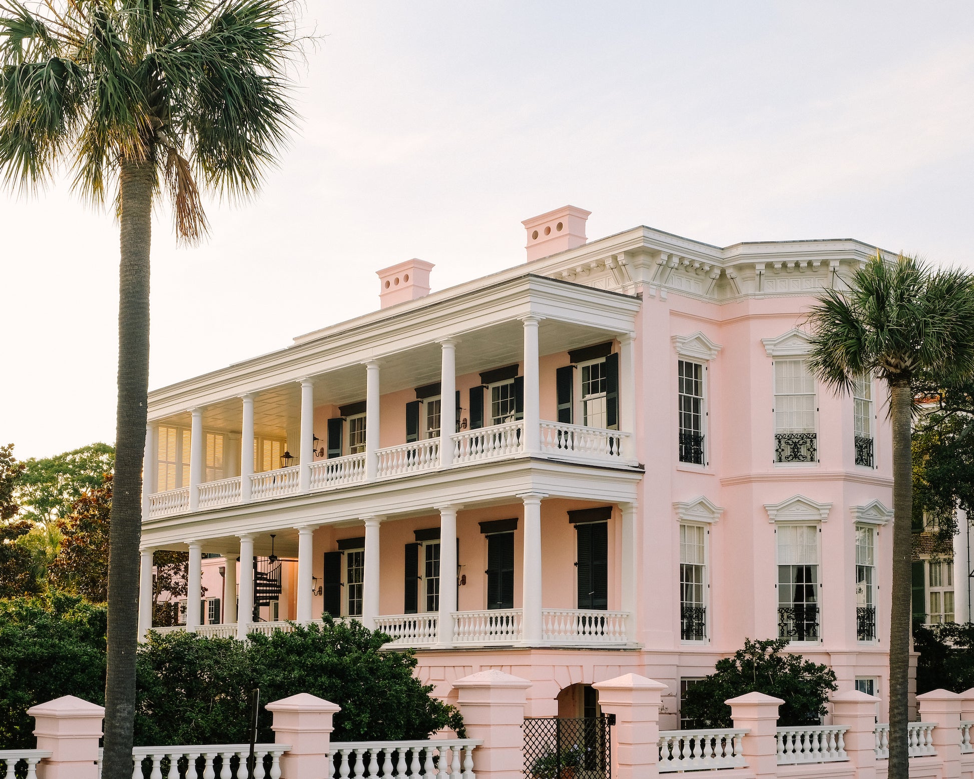 Pink historic home on the Battery in Charleston with palm trees and classic architecture