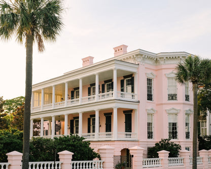 Pink historic home on the Battery in Charleston with palm trees and classic architecture